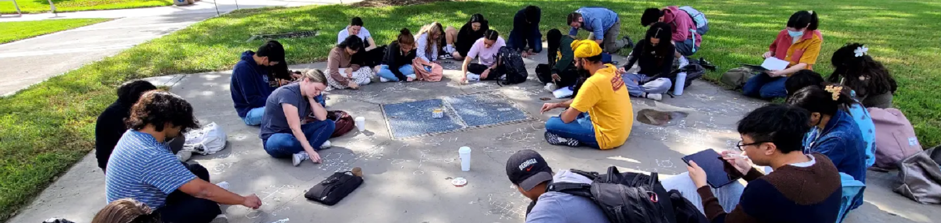 Students drawing on concrete during office hours