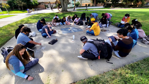 CNAS students drawing on concrete during office hours