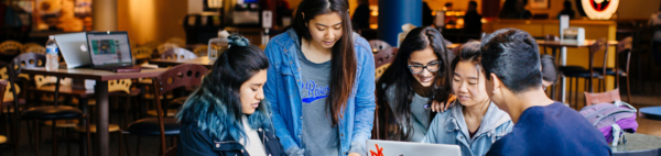 Students sitting at tables in the HUB