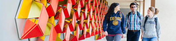 Students walking past genomics building art installation