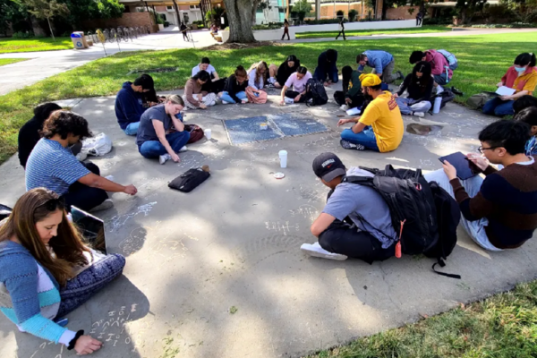 UC Riverside students studying & drawing on the concrete