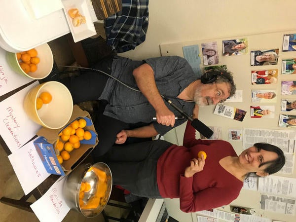 Marketplace reporter Mitchell Hartman offers a tangerine taste test to a participant at a holiday potluck