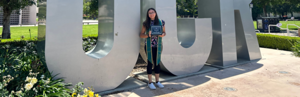 CNAS student standing by UCR sign