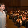 Student asking a question at a microphone during a lecture.