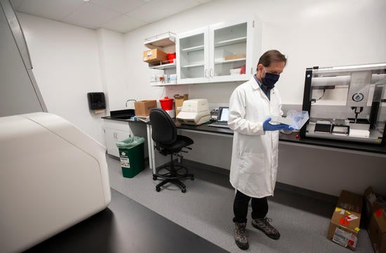 Matthew Collin, genomics core manager, sets up the COVID-19 testing laboratory
