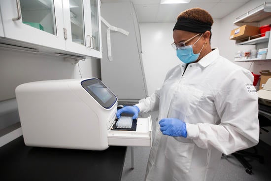 Juliet Morrison runs a test on equipment in UC Riverside’s COVID-19 testing laboratory